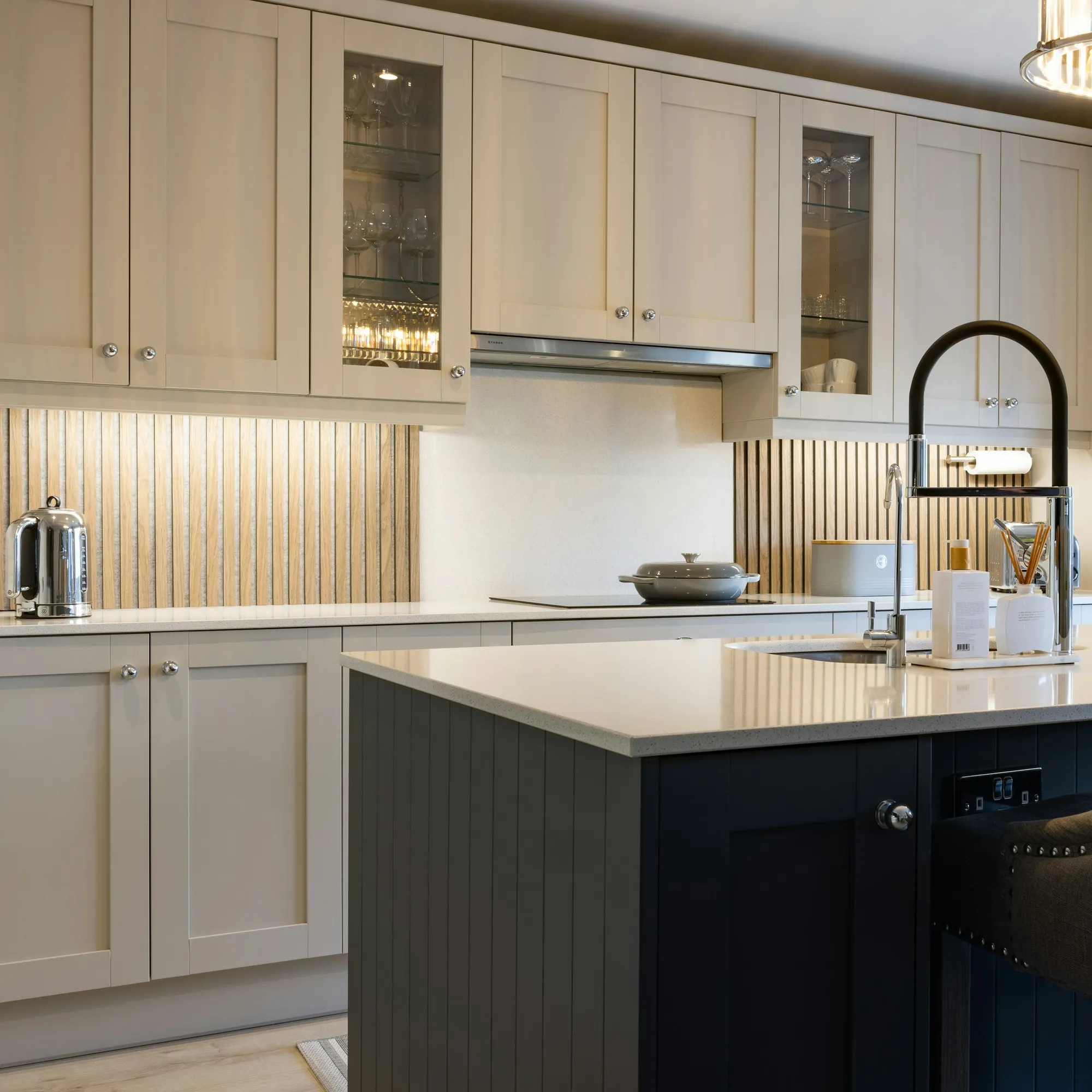 Cream shaker kitchen with a navy fluted island and a black tap