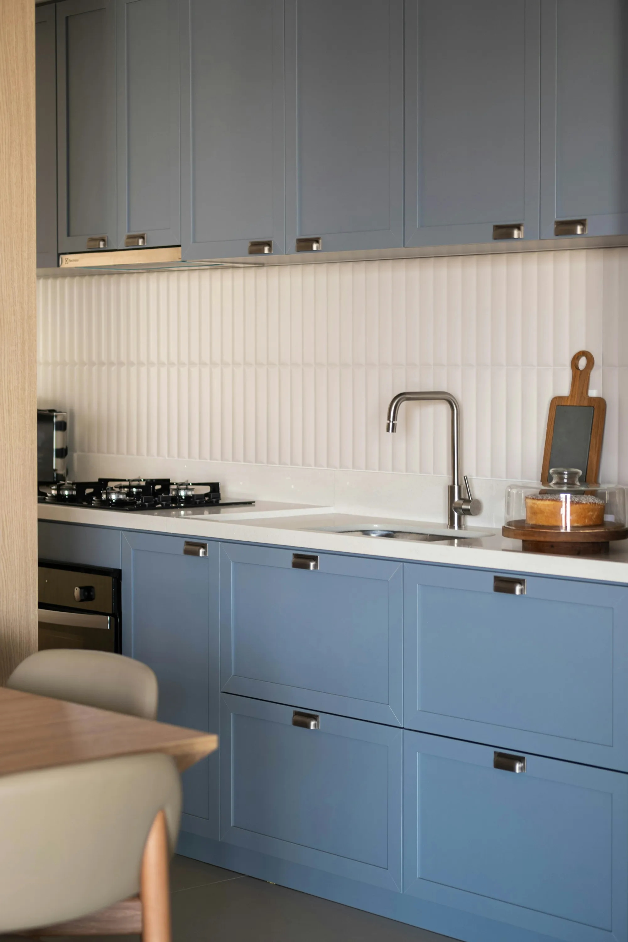 Blue shaker base cabinets with a white worktop