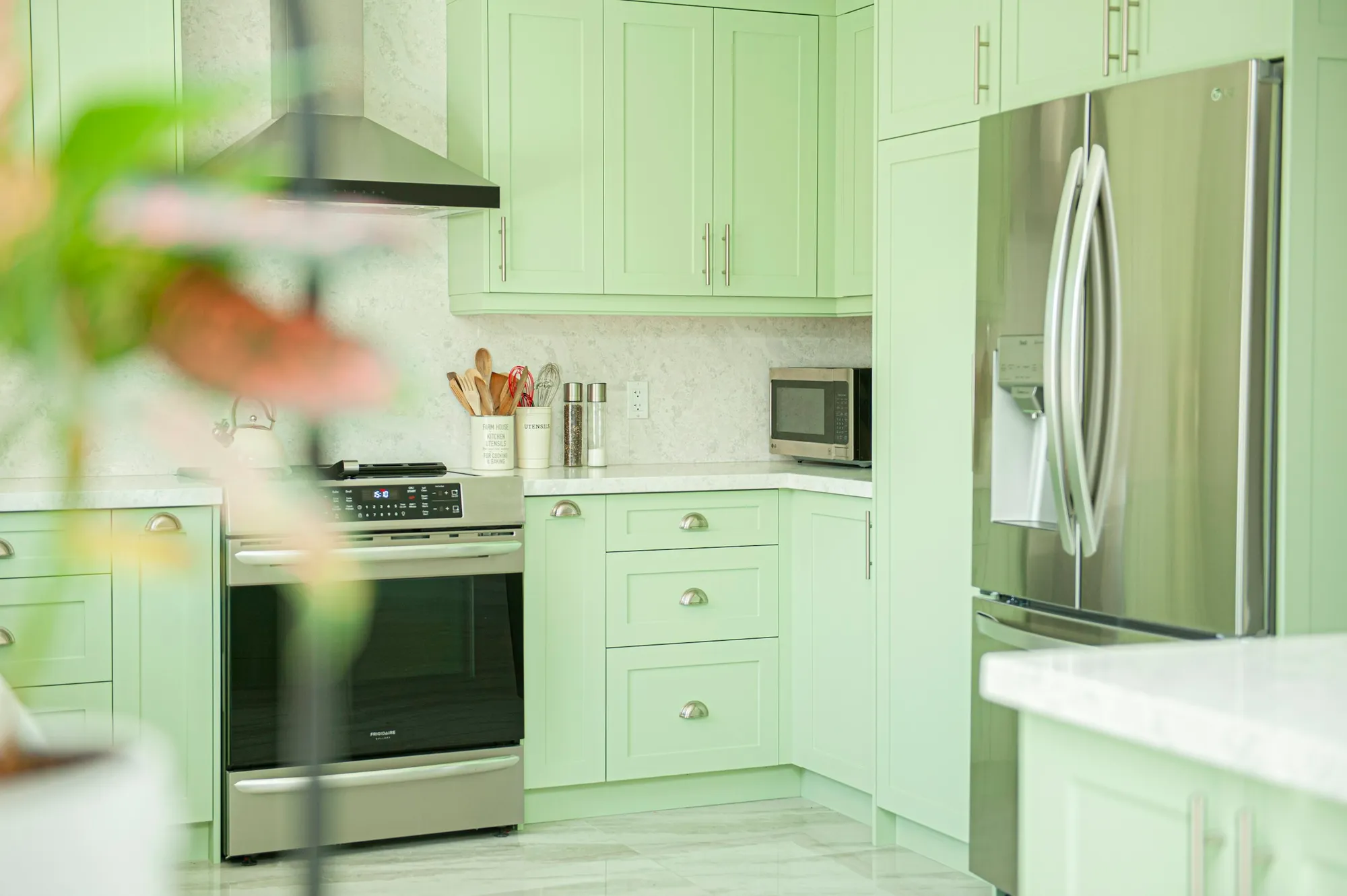 Pale green shaker cabinets with brass knobs