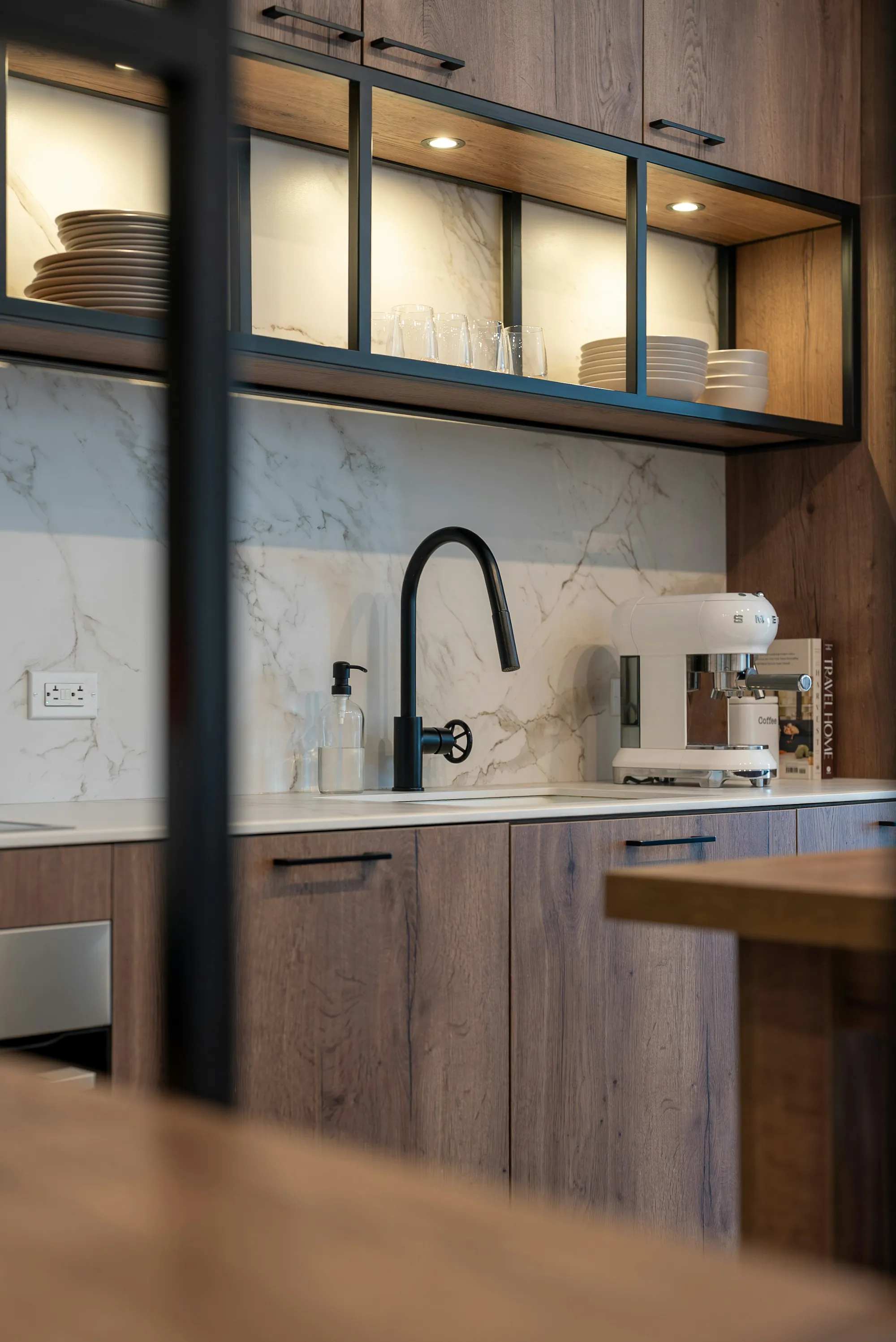 Oak base cabinets with a marble splashback and a black tap
