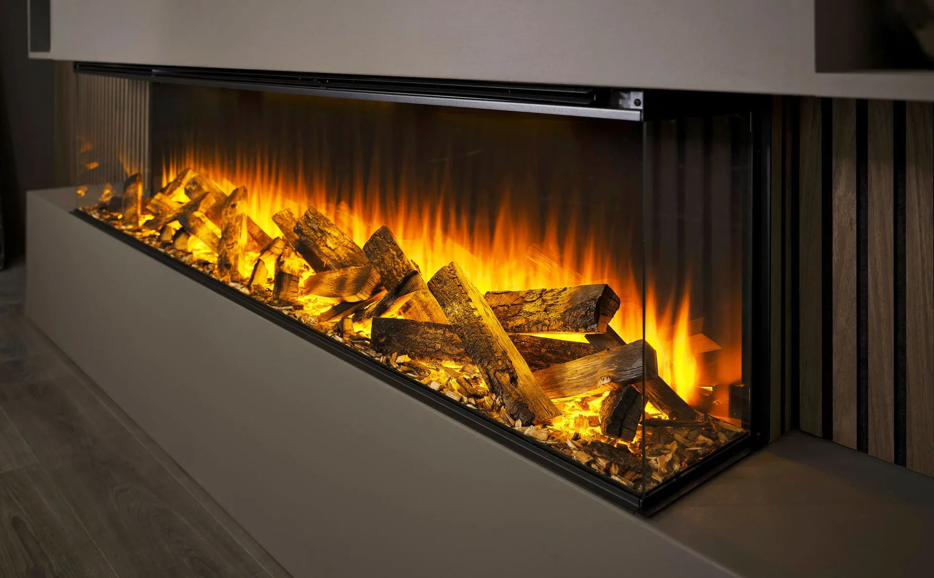 British Fires three-sided electric fire with glowing oak logs set into a panelled wall