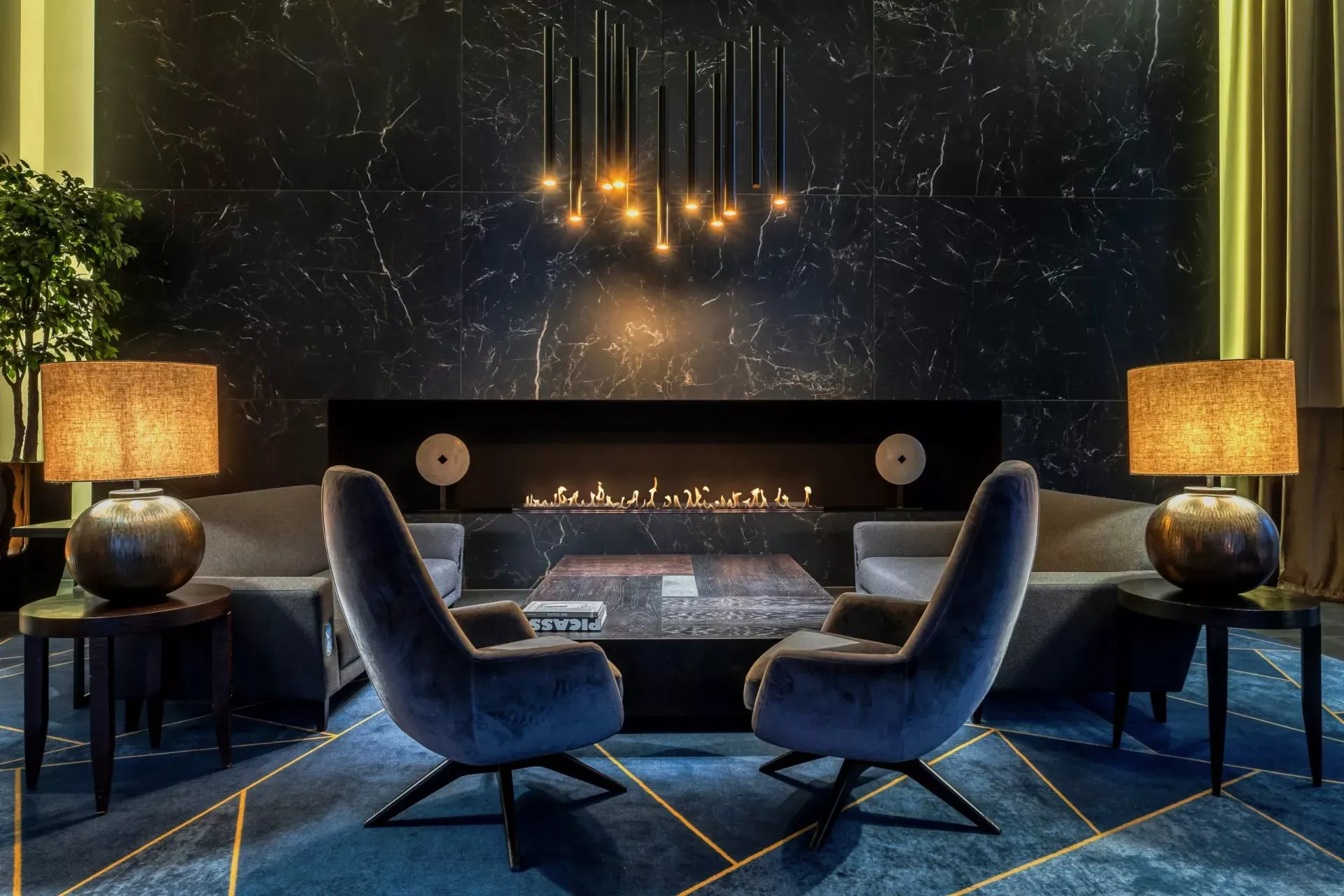 Planika linear fireplace in a dark lounge with two armchairs