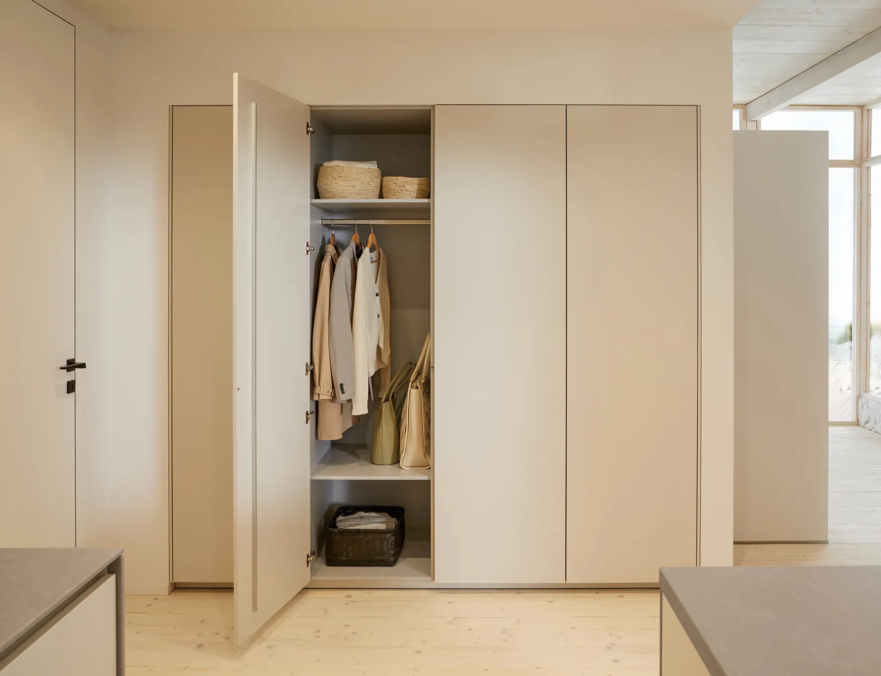 Tall fitted wardrobe with an open door revealing hanging space