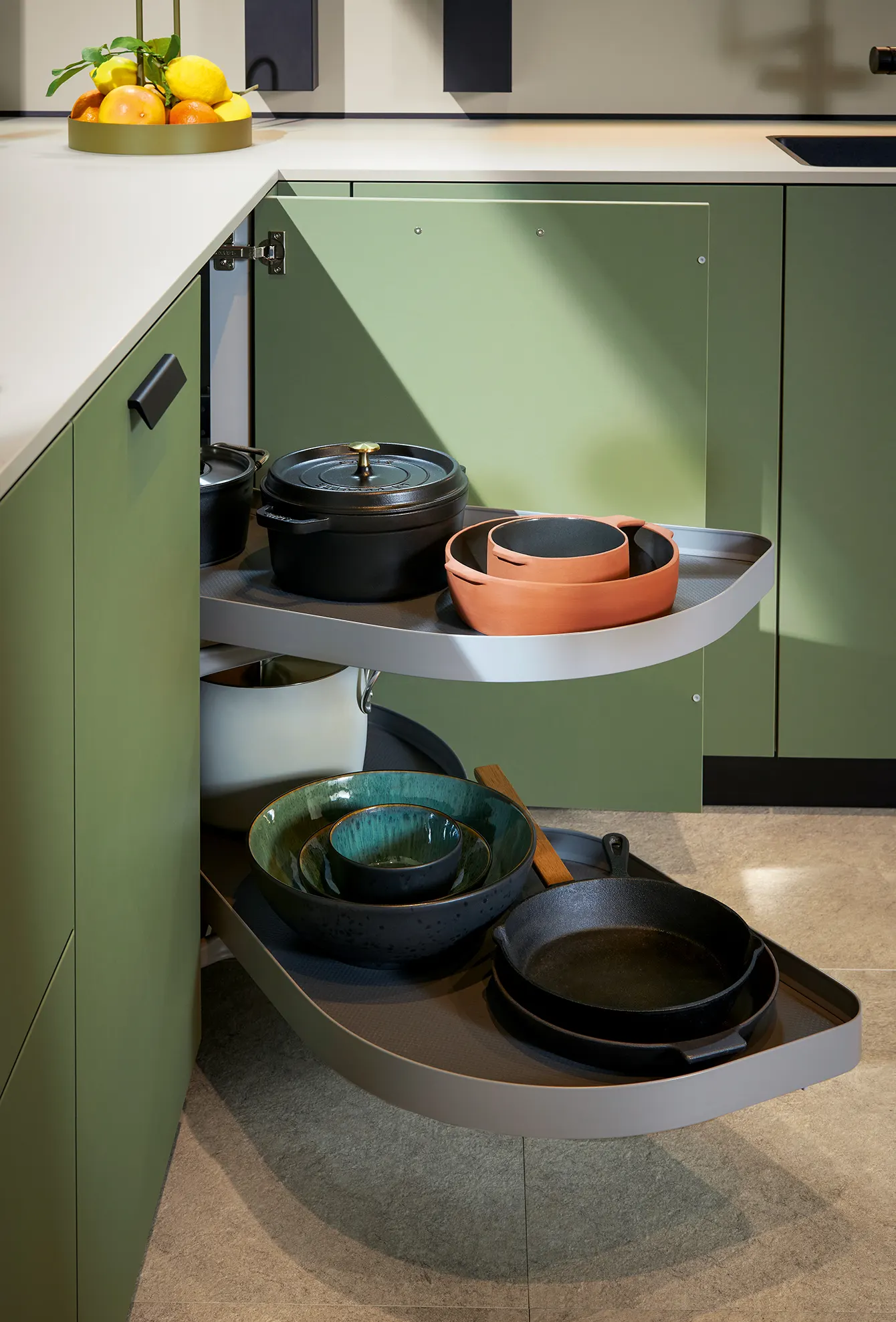 Corner pull-out storage with cookware in a green kitchen