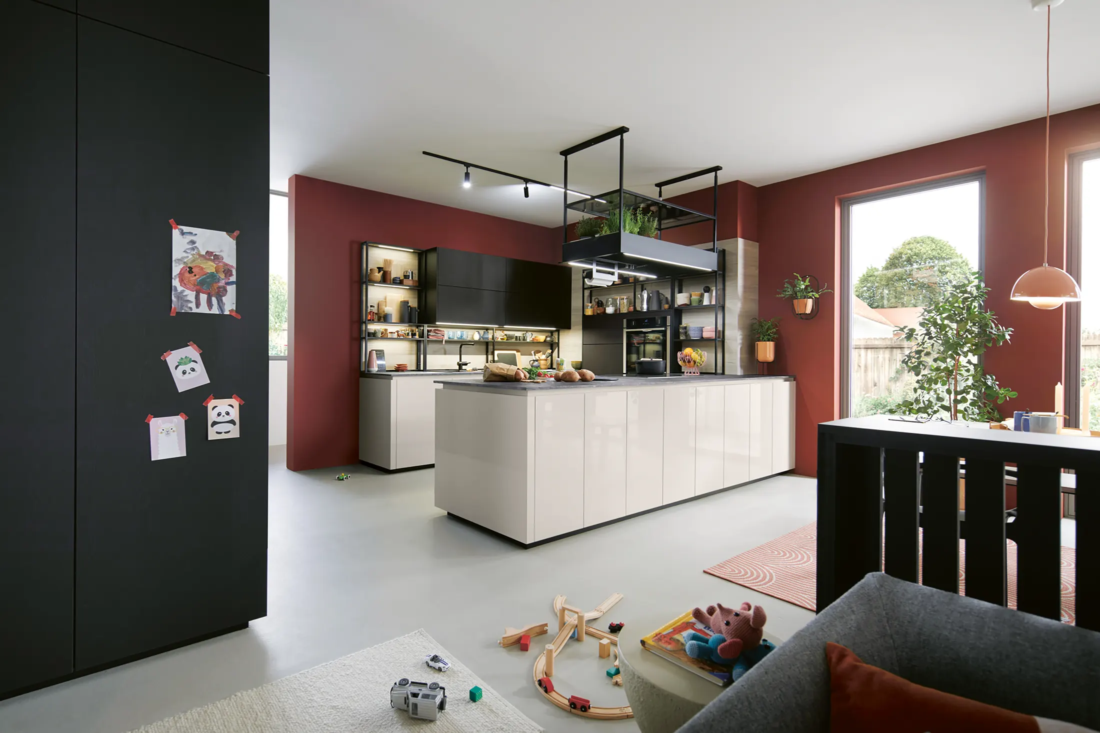 Deep red and cream kitchen island with a lit open space beyond