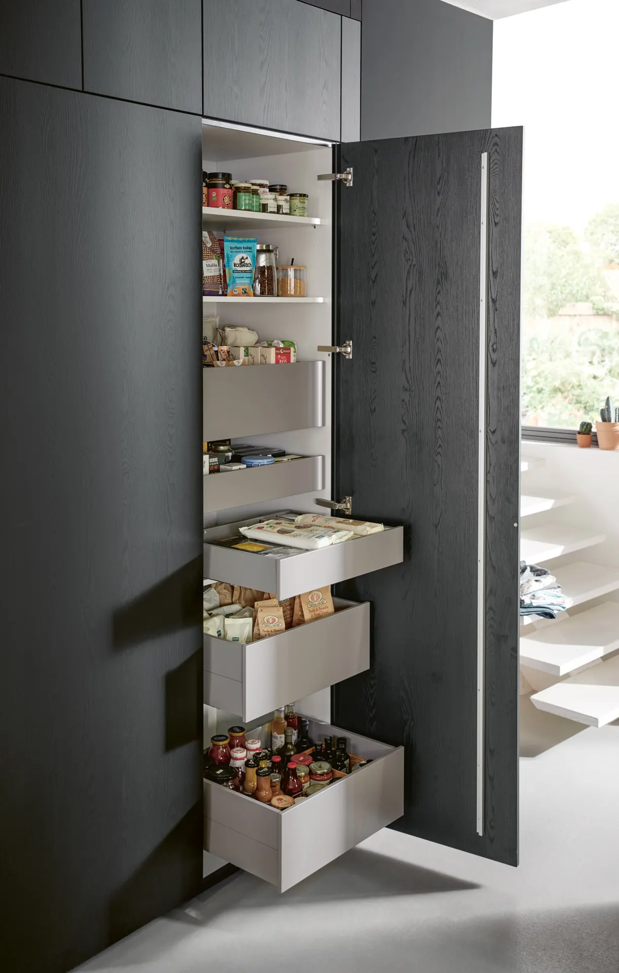 Tall pull-out larder in a dark timber kitchen