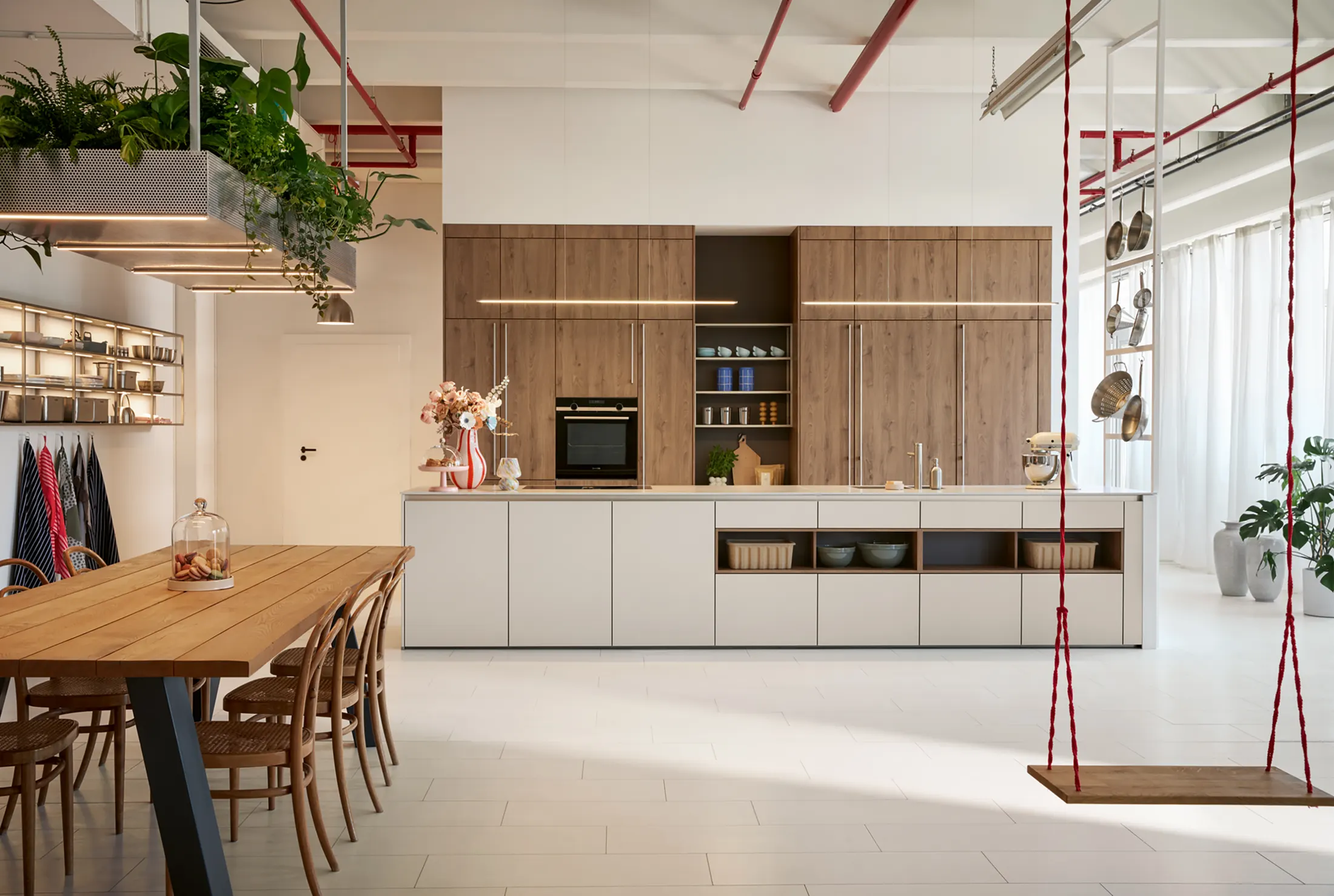 Oak and anthracite kitchen with a dark worktop and green planting