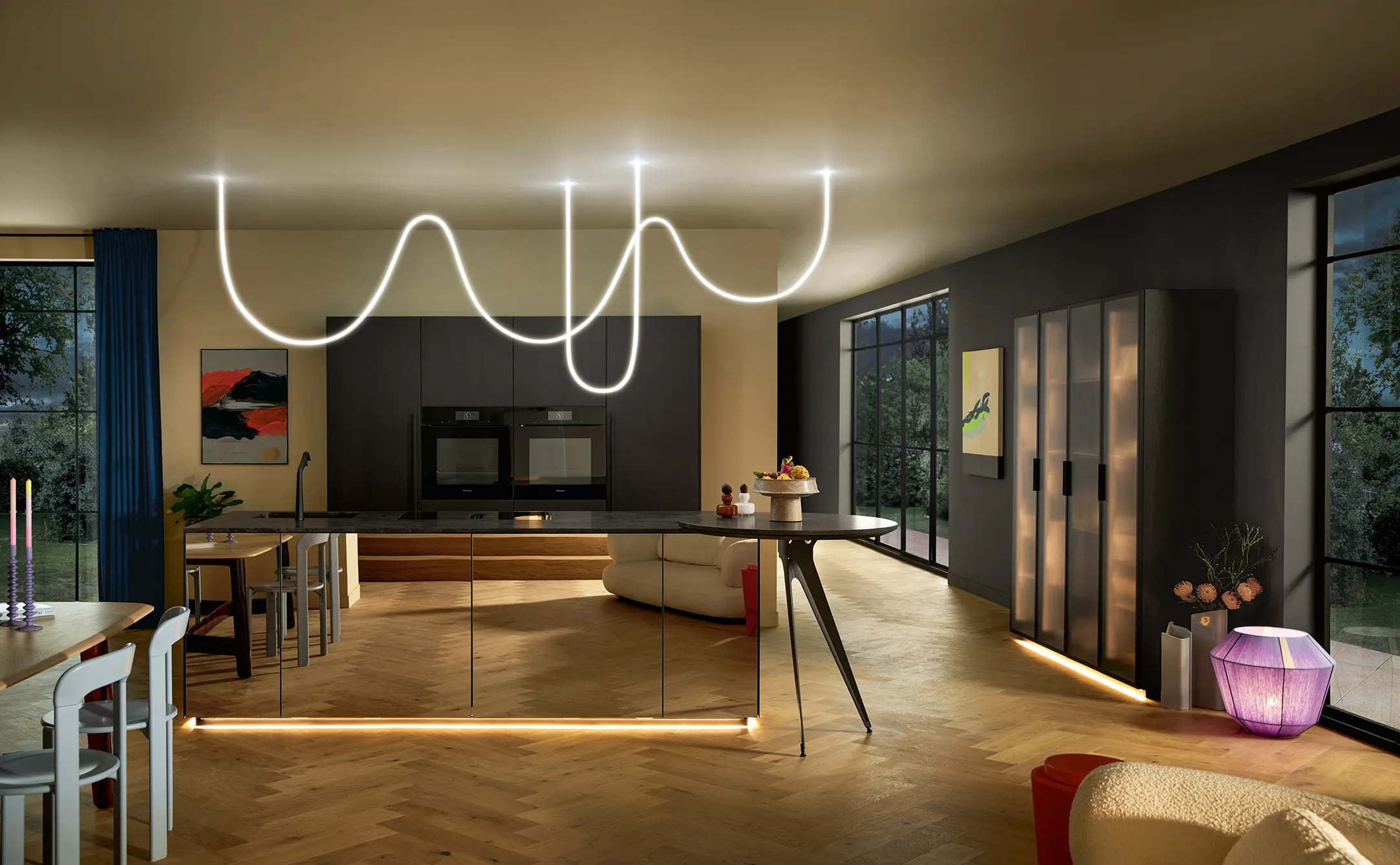 Dark kitchen with black tall units, a mirrored island and a glowing light line