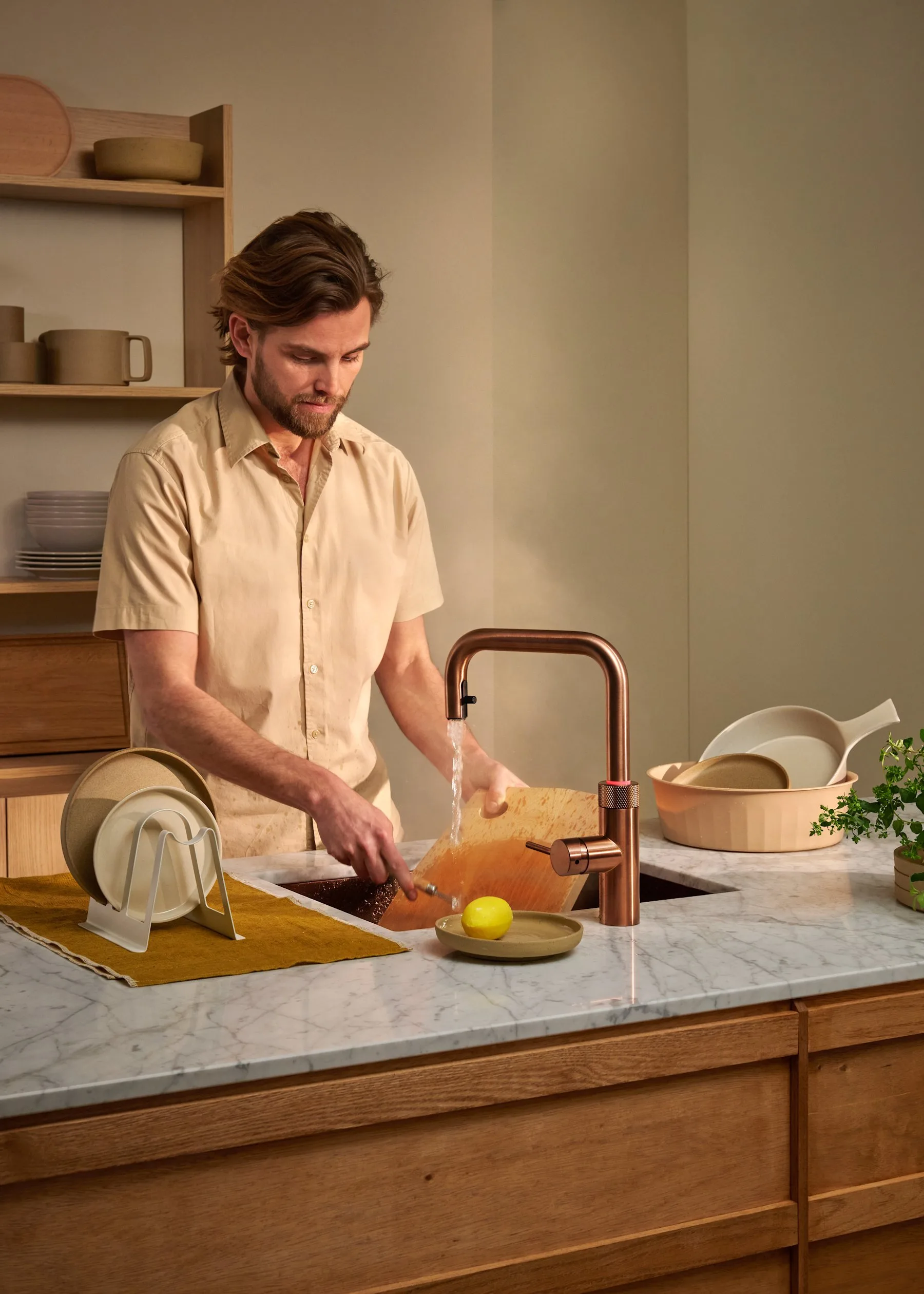 Quooker Flex Square tap in rose copper over a sink in a marble worktop
