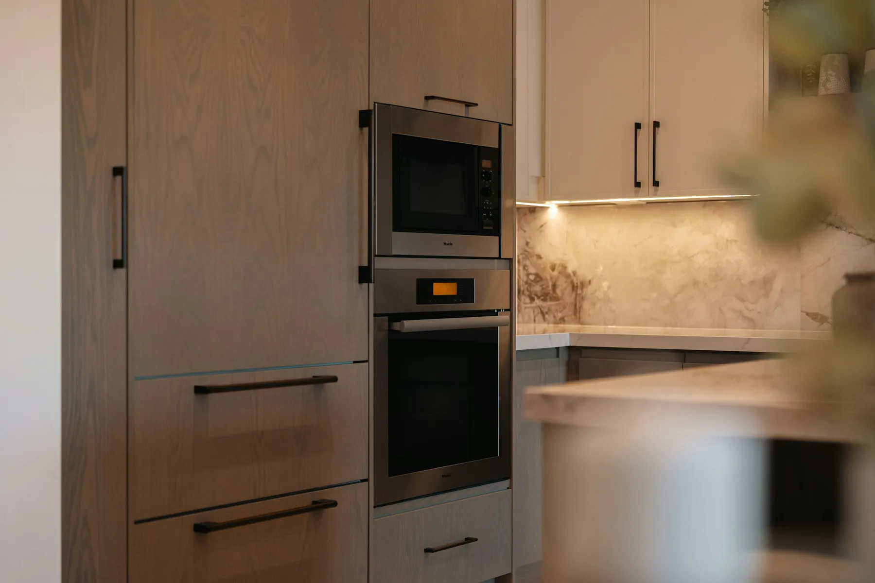 Built-in oven and microwave stacked in oak cabinetry