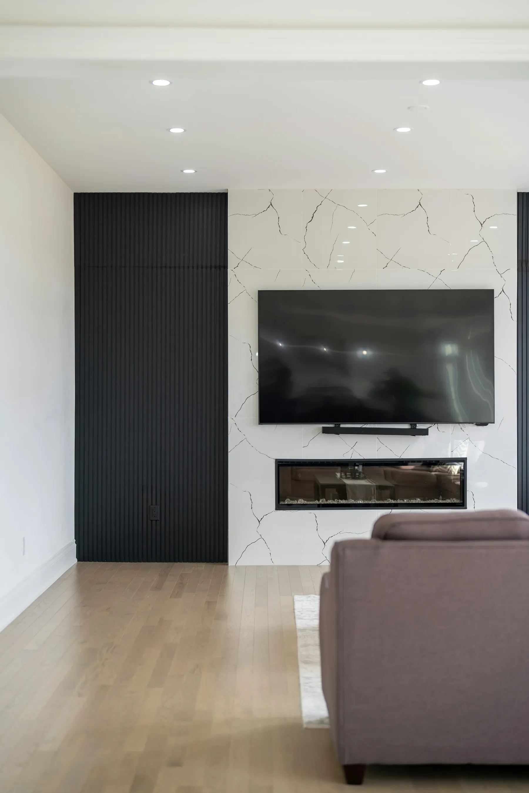 Marble-effect media wall with a television above a slim linear fireplace