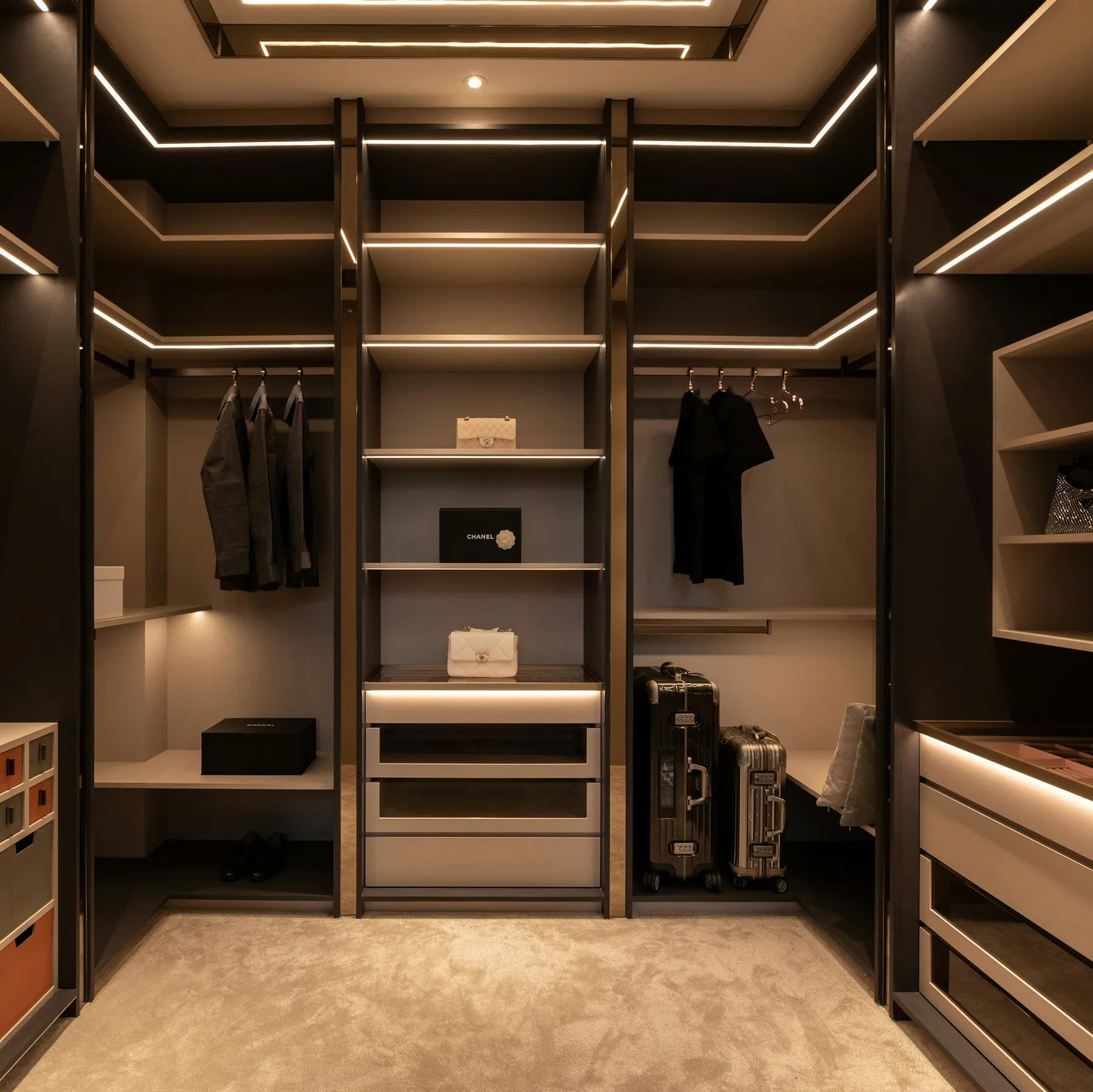 Dark walk-in wardrobe with integrated lighting and open shelving
