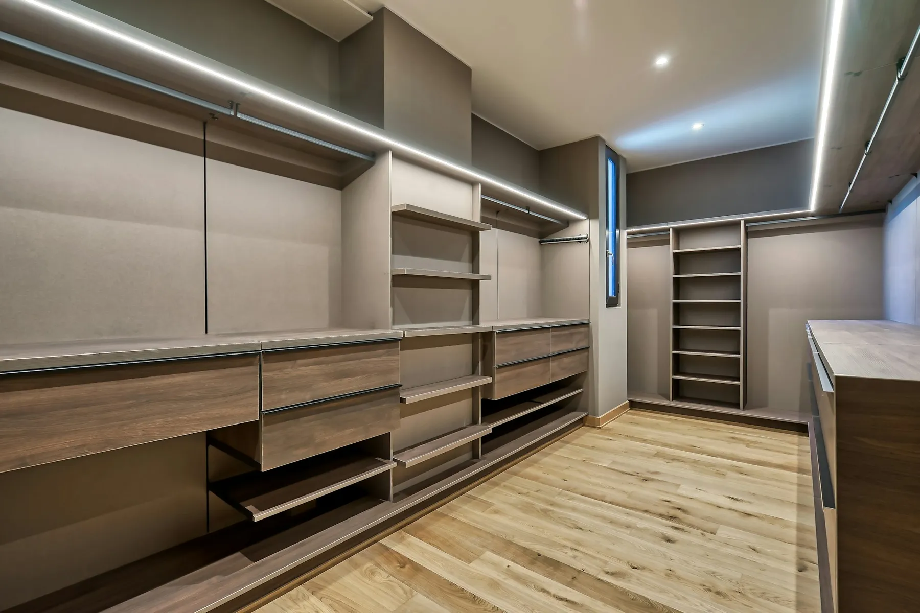 Walk-in wardrobe with LED lighting, drawers and oak flooring