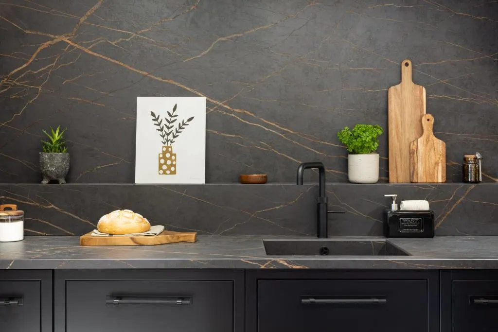 Dark stone worktop with an undermount sink and black tap