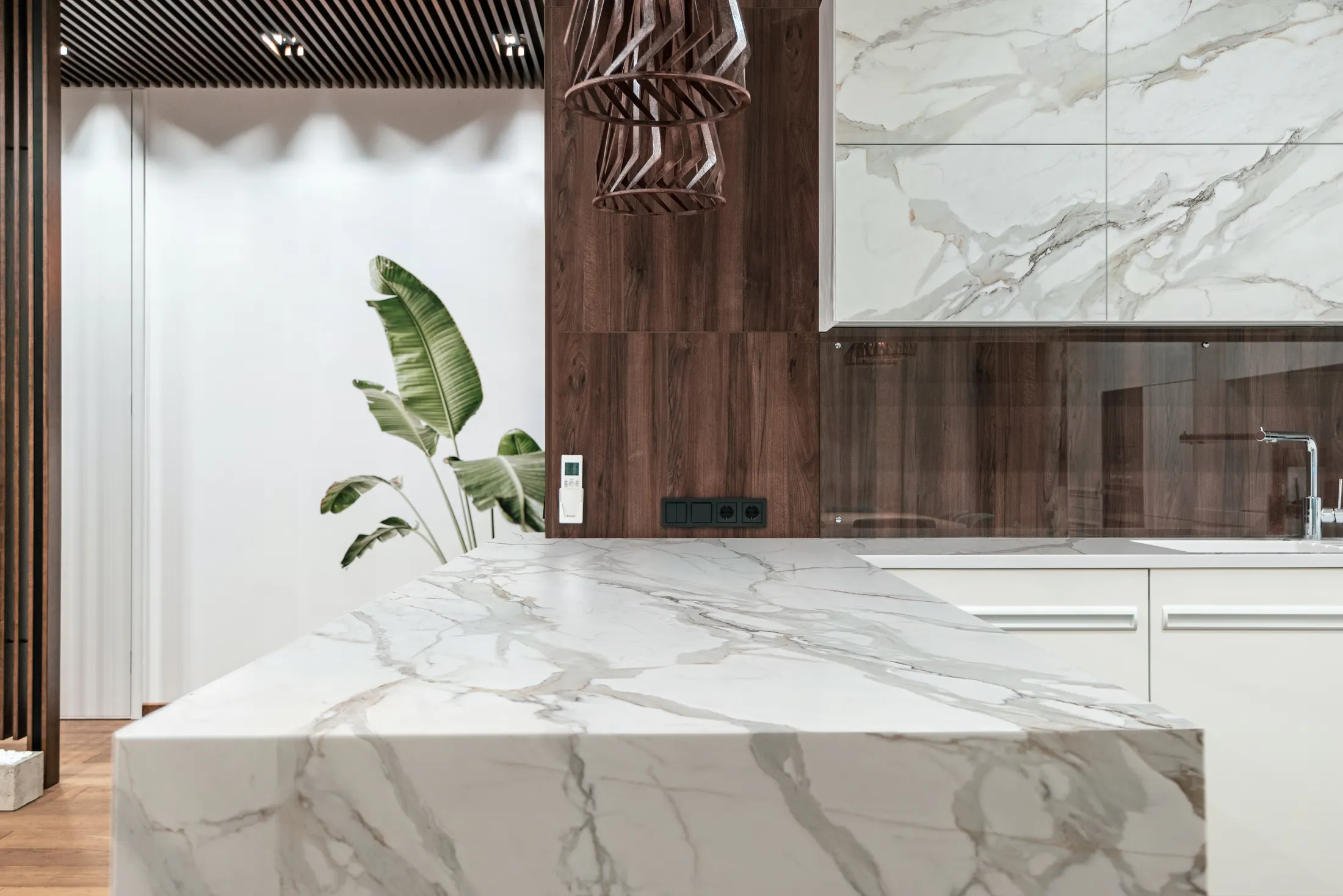 Dark stone splashback with gold veining behind a kitchen worktop